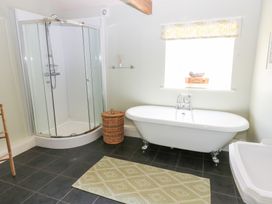 A bathroom with a shower and bathtub at Shepherds Burn Cottage Bellingham