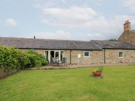 A cottage with seating area and garden at Shepherds Burn Cottage in Bellingham