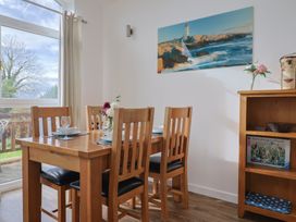 A dining room with a wooden table and chairs at Keepers Cottage in Sidmouth