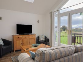 A snug room with a sofa and television at Keepers Cottage in Sidmouth