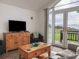 A living room with a television and wooden furniture at Keepers Cottage in Sidmouth