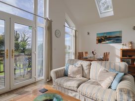 A living room with a sofa and dining area at Keepers Cottage in Sidmouth