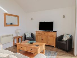 A living room with a television and furniture at Keepers Cottage in Sidmouth