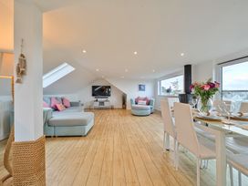 A living room with a sofa and dining table at Sunset View in Porth