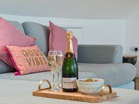 A living room with champagne and snacks at Sunset View in Porth