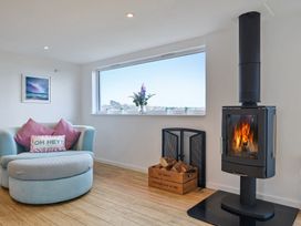 A living room with a fireplace and armchair at Sunset View in Porth
