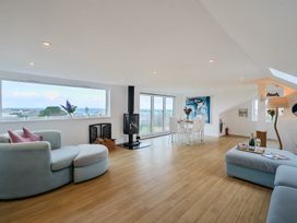 A living room with a dining area and large windows at Sunset View in Porth