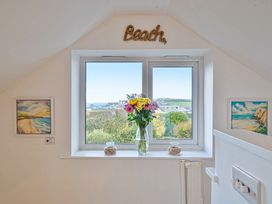 A window with flowers and artwork at Sunset View in Porth