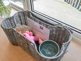 A wicker basket with a teddy bear and bowl at Sunset View in Porth