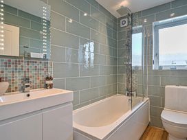 A bathroom with bathtub, toilet, and sink at Sunset View in Porth