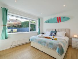 A bedroom with a bed and windows at Sunset View in Porth