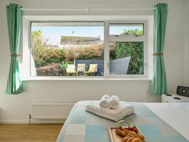 A bedroom with a window overlooking a garden at Sunset View in Porth
