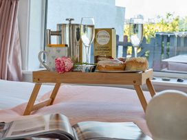 A breakfast tray with drinks and snacks on a bed at Sunset View in Porth