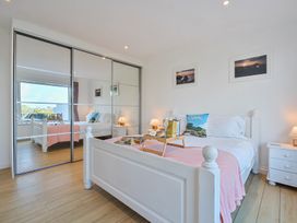 A bedroom with a bed and mirrored wardrobe at Sunset View in Porth