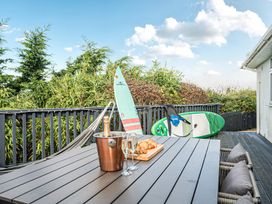 An outdoor dining area with surfboards on display at Sunset View in Porth