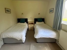 A bedroom with two single beds and a nightstand at Lodge 22, Bodmin Holiday Park, Cornwall, Lanivet