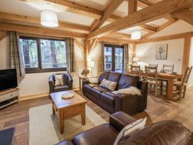 A living room with a sofa and dining table at Lady Bagots Cabin in Ruthin