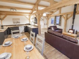 A kitchen with a dining area and sofa at Lady Bagots Cabin in Ruthin