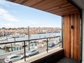 A balcony overlooking the harbor with boats and cars at Harbour Sunset in 