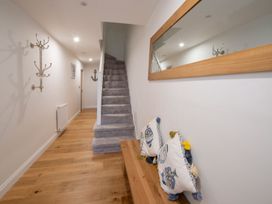 A hallway with a staircase and a wooden bench at Harbour Sunset