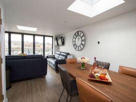 A living room with a table and chairs at Harbour Sunset 