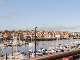 A harbor scene with boats and buildings at Harbour Sunset in 