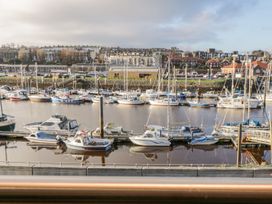 A harbor with boats and buildings in the background at Harbour Sunset in 