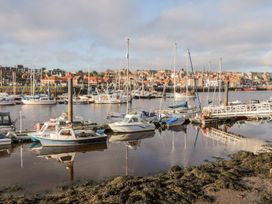 A marina with boats and buildings reflected in the water at Harbour Sunset