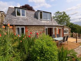 A house with a deck and outdoor furniture at Mallows Byre in Yetminster
