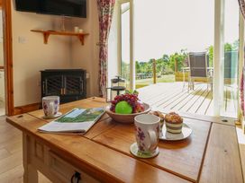 A living room with a table and fruit at Mallows Byre in Yetminster