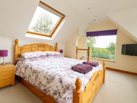 A bedroom with a bed and window at Mallows Byre in Yetminster