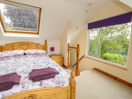 A bedroom with a bed and window at Mallows Byre in Yetminster