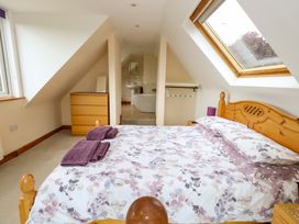 A bedroom with a bed and wardrobe at Mallows Byre in Yetminster