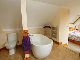 A bathroom with a bathtub and toilet at Mallows Byre in Yetminster