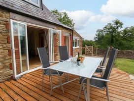 An outdoor dining area with a table and chairs at Mallows Byre in Yetminster