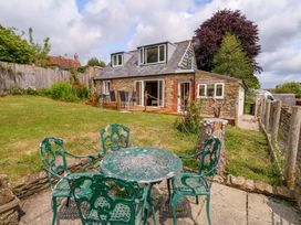 A garden with a table and chairs at Mallows Byre Yetminster