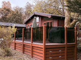 A deck area with a grill and seating at Coniston Number 9 in White Cross Bay
