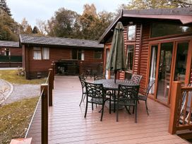 An outdoor patio with a table and chairs at Coniston Number 9, White Cross Bay