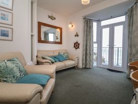 A living room with a glass door and seating at Close to Shore