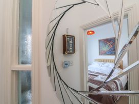 A bedroom with a bed and artwork visible through a mirror at Close to Shore