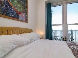 A bedroom with a bed, window and balcony at Close to Shore