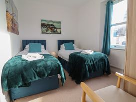 A bedroom with two single beds and artwork on the wall at Close to Shore