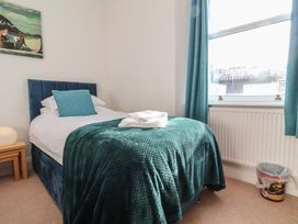 A bedroom with a single bed and a window at Close to Shore