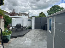 A garden with a table and chairs on decking at Jakanori Staveley