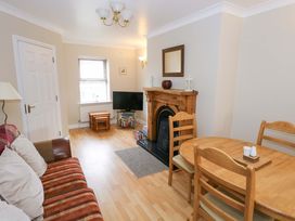 A living room with a sofa, dining table and television at Aisling in Foxford near Ballina, County Mayo