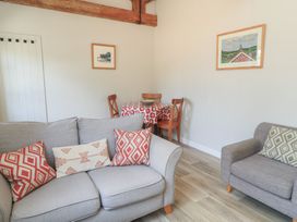 A living room with a sofa and dining area at The Cider Press, Motcombe