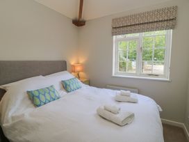 A bedroom with a bed and a lamp at The Cider Press, Motcombe