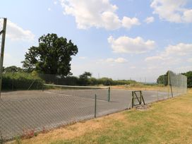 A tennis court with a net and fence at The Cider Press, Motcombe, Shaftesbury