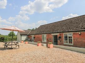 An outdoor area with a picnic table and parasol at The Apple Shed, Motcombe