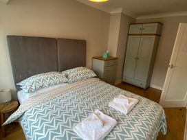 A bedroom with a bed and wardrobe at No. 1 Kelly Cottages, Scarborough